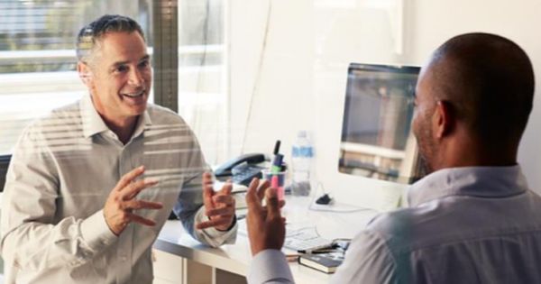 two men talking to each other in an office