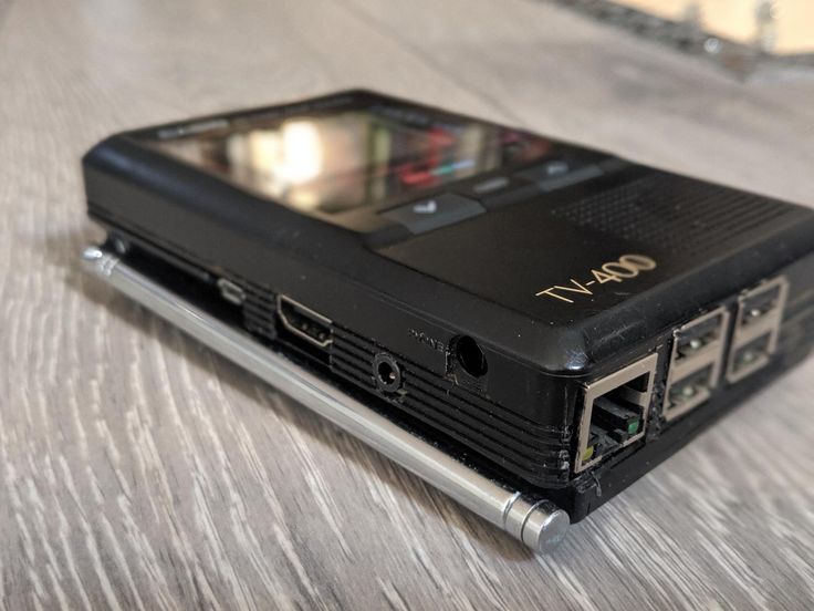 a black cell phone sitting on top of a wooden table