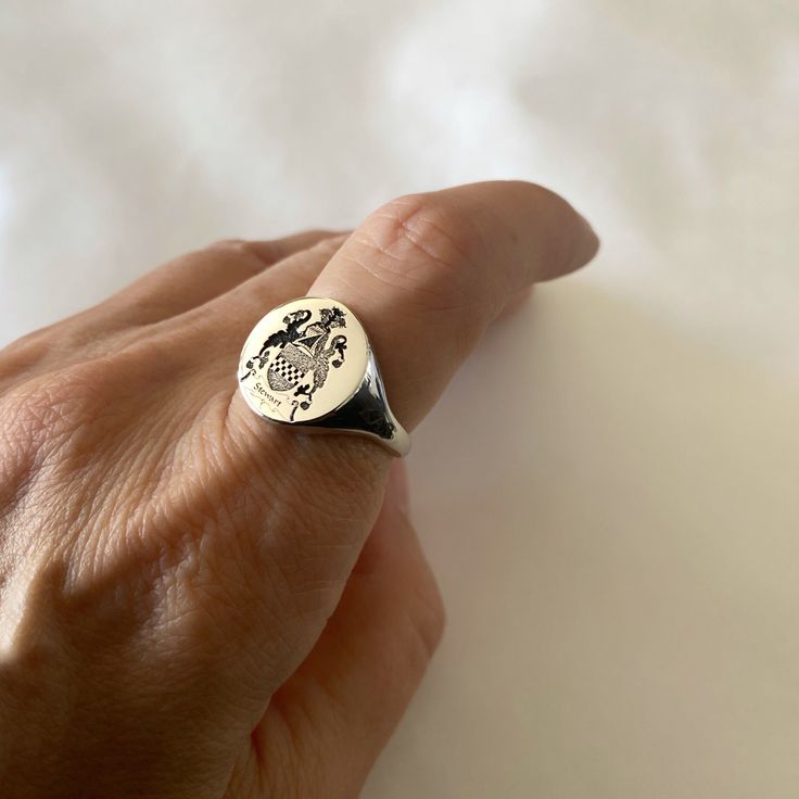 "Coat of Arms Family Crest Ring, Crest Engraved ring, Personalized Ring Engraved Signet ring with Round Seal - Best quality 18k Gold Plate also avaliable in sterling silver - suitable for men and women, Diameter: 15 mm  Please note in the \"notes to seller\" at checkout. : * state your ring size  * letter/ picture you want to engrave The product will arrive to you packed in gift box and padded envelope to maintain the product Our jewelry are water resistant and comes with 1 year warranty For more rings from us: https://www.etsy.com/il-en/shop/Limajewelry?section_id=16284797&ref=shopsection_leftnav_1  Thank you for your interest. Please check out our other items and be sure to add us to your favorites! https://www.etsy.com/shop/Limajewelry We look forward to the opportunity of serving you." Adjustable Symbolic Signet Ring For Anniversary, Symbolic Hallmarked Signet Ring Gift, Symbolic Engraved Hallmarked Ring As Gift, Symbolic Engraved Hallmarked Ring For Gift, Personalized Adjustable Symbolic Signet Ring, Engraved Sterling Silver Dome Ring As Gift, Adjustable Symbolic Personalized Signet Ring, Symbolic 925 Stamped Engraved Ring As Gift, Adjustable Personalized Symbolic Signet Ring