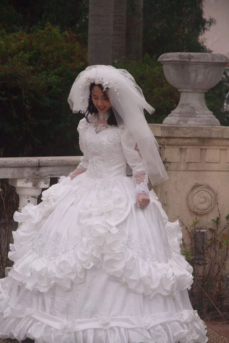 a woman in a white wedding dress and veil