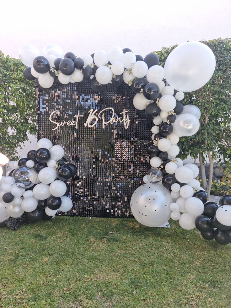 a black and white balloon arch with some balloons on it in the shape of a square