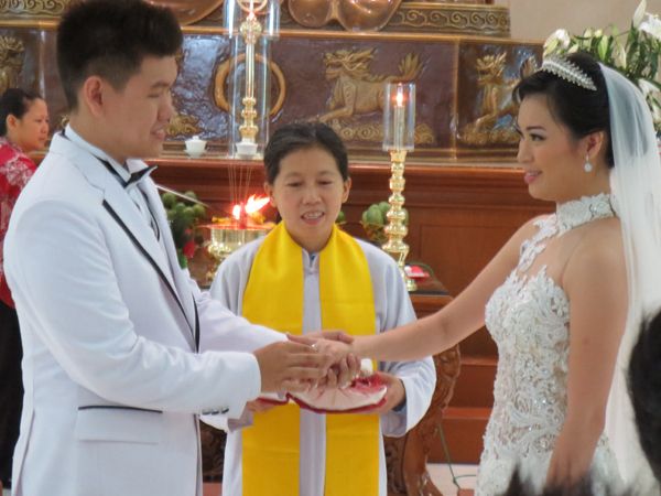 the bride and groom are exchanging their wedding vows at the altar in front of other people