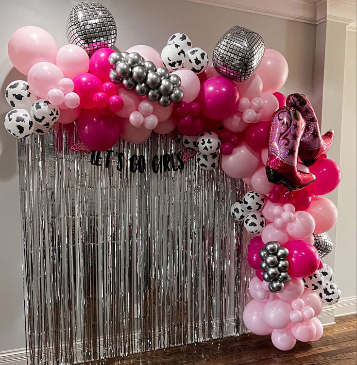 the balloon arch is decorated with black and white polka dots, pink and silver balloons