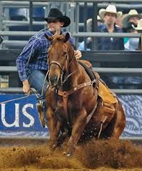 a man riding on the back of a brown horse in an arena at a rodeo