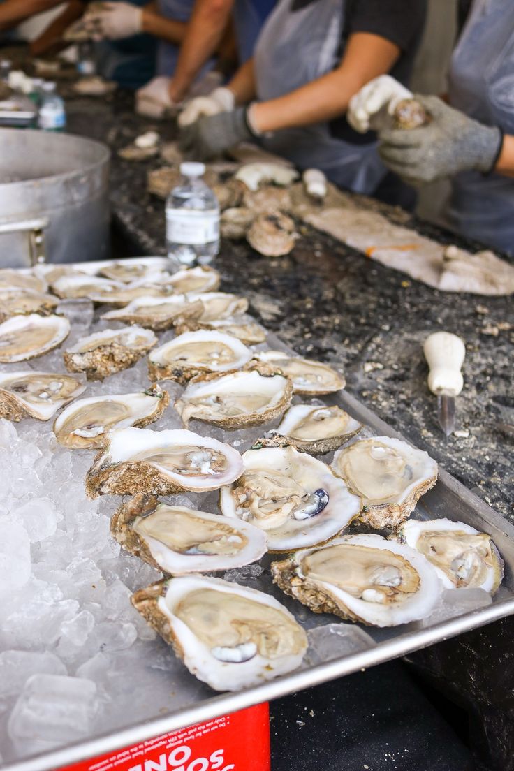 oysters are being prepared on an ice tray at a seafood market in the united states