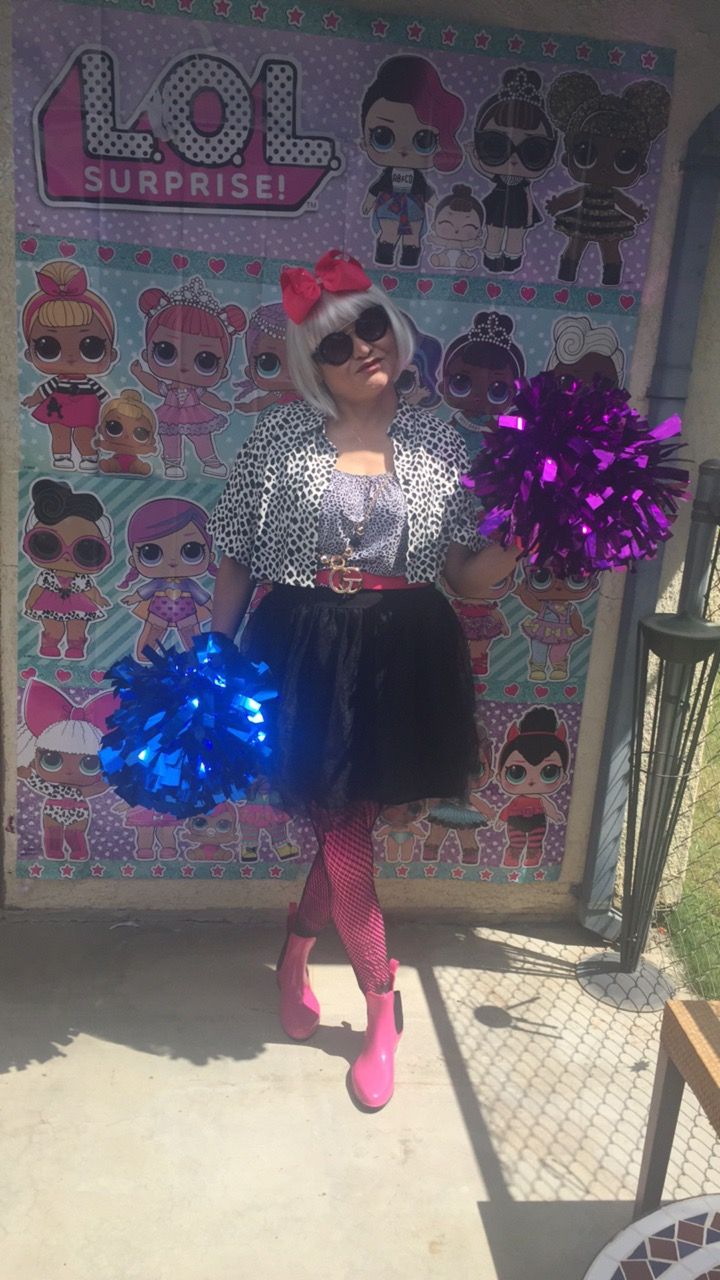 a woman in pink and black outfit holding cheerleader pom poms