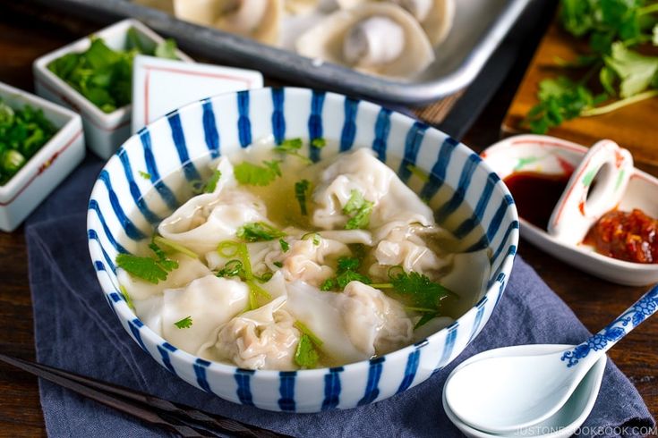 dumplings and pork wonton soup in blue and white striped bowl with chopsticks