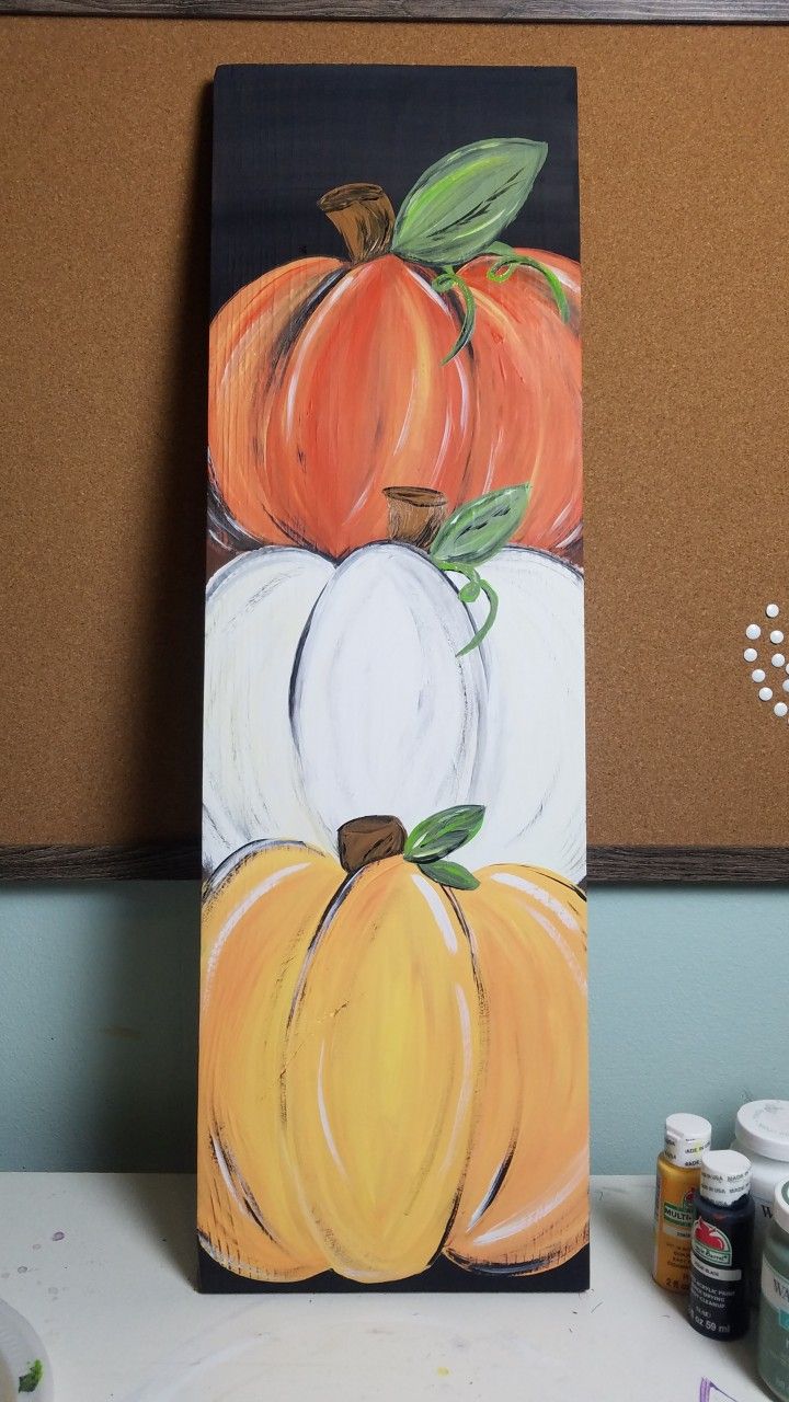 an acrylic painting of pumpkins and gourds on a black board