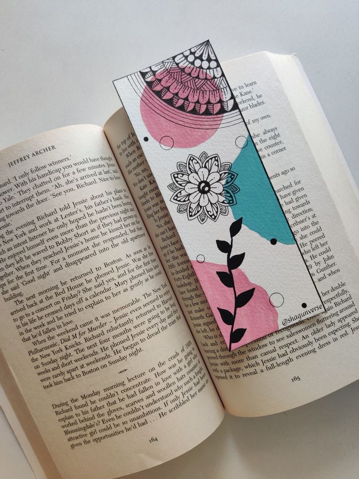 an open book with colorful designs on the pages and a tag attached to it's cover