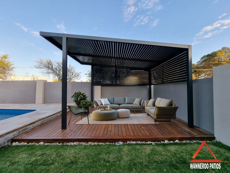 an outdoor living area with couches, tables and a swimming pool in the background