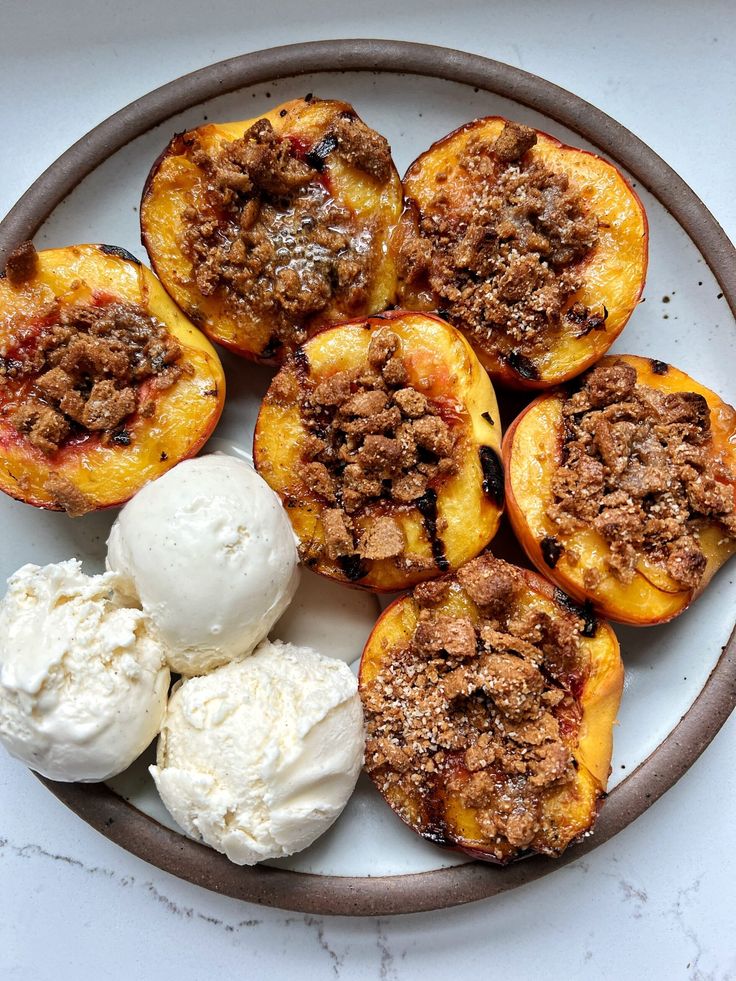 a white plate topped with peaches and ice cream on top of a marble counter