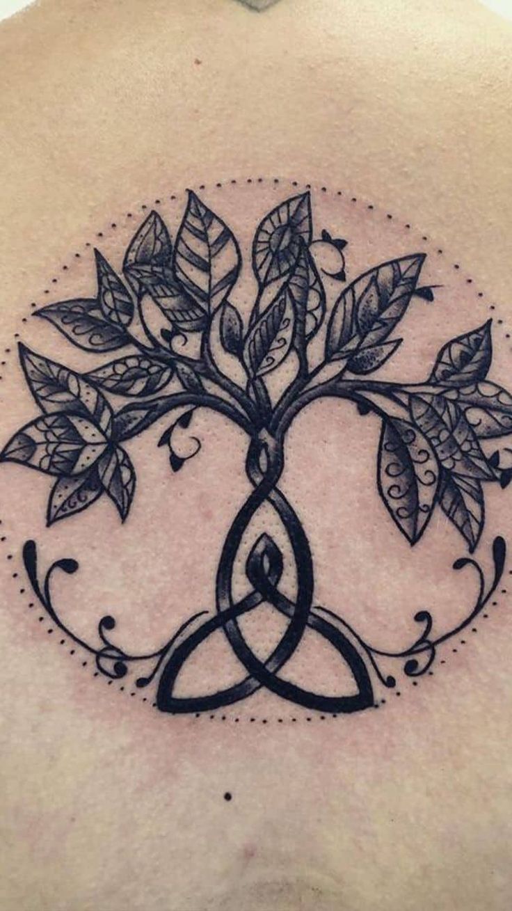 the back of a man's shoulder with a tree and two leaves on it