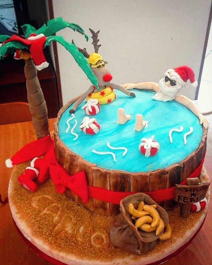 a decorated cake on top of a wooden table next to a tree and other decorations