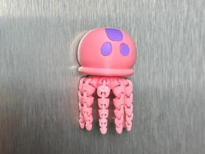 a pink and purple jellyfish toy hanging from the side of a metal wall,