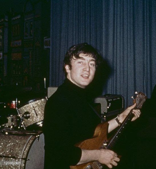 two men are playing guitars in a room