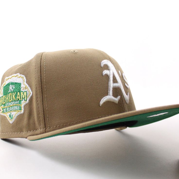 Oakland Athletics Hohokam Stadium 70 Season New Era 59Fifty Fitted Hat in Khaki, Green Under Brim. The Logo has that beautiful metallic Iris That you all have been searching for ! Custom Caps, Green Bottom, New Era Cap, New Era 59fifty, Oakland Athletics, 47 Brand, Fitted Caps, Brim Hat, Mitchell & Ness