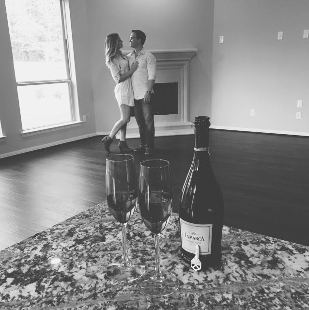 a man and woman standing next to two wine glasses