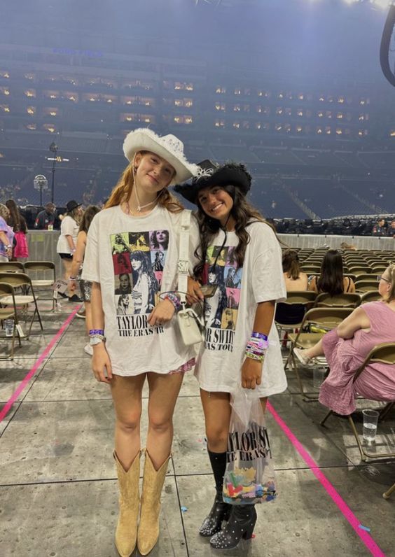 two women standing next to each other at a stadium