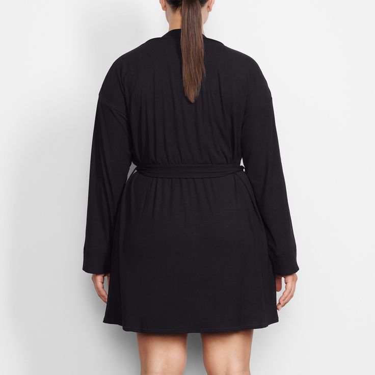 Perfect for lounging and layering over sleepwear, the Soft Lounge Robe is composed of super-soft modal ribbed fabric that drapes effortlessly in all the right places. This short robe features an adjustable self-tie belt and functional side pocket at inseam. | SKIMS Robe | Black | Soft Lounge V-neck Robe With Tie Waist For Loungewear, Long Sleeve Robe With Tie Waist For Lounging, Tie Waist Wrap Sleepwear, Tie Waist Wrap Sleepwear For Loungewear, Wrap Sleepwear With Tie Waist For Loungewear, Modal Sleepwear For Sleep, Solid Modal Sleepwear, Long Sleeve Tie Waist Sleepwear For Lounging, Long Sleeve Sleepwear With Tie Waist For Lounging