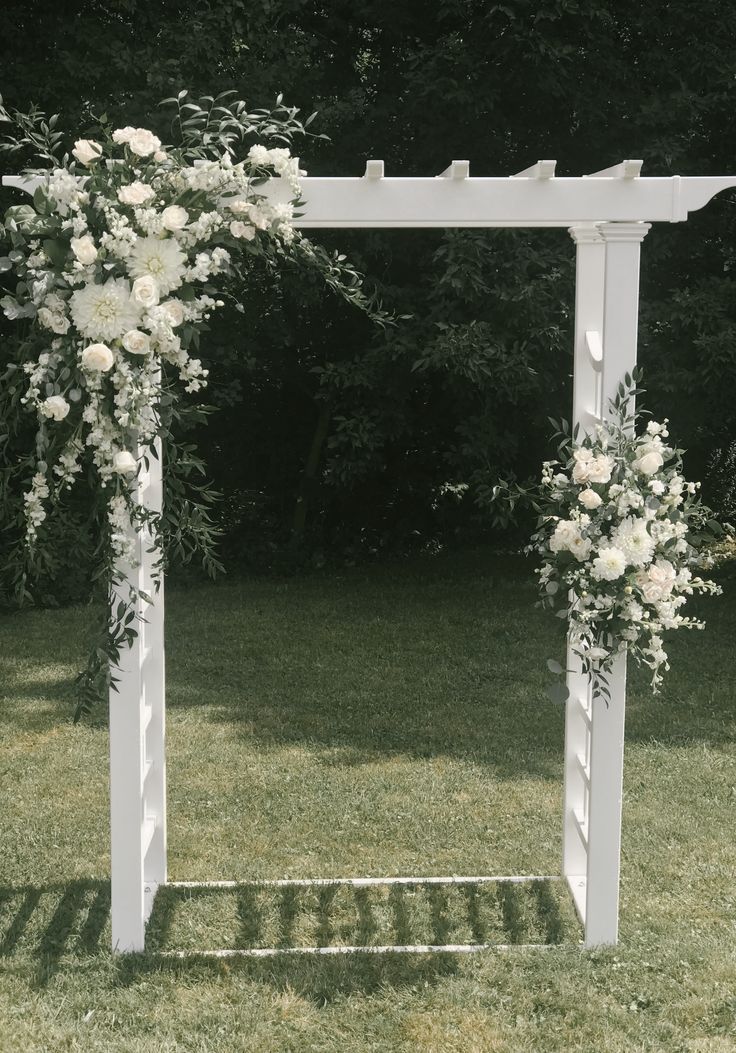 an outdoor wedding ceremony setup with white flowers and greenery on the side of the aisle