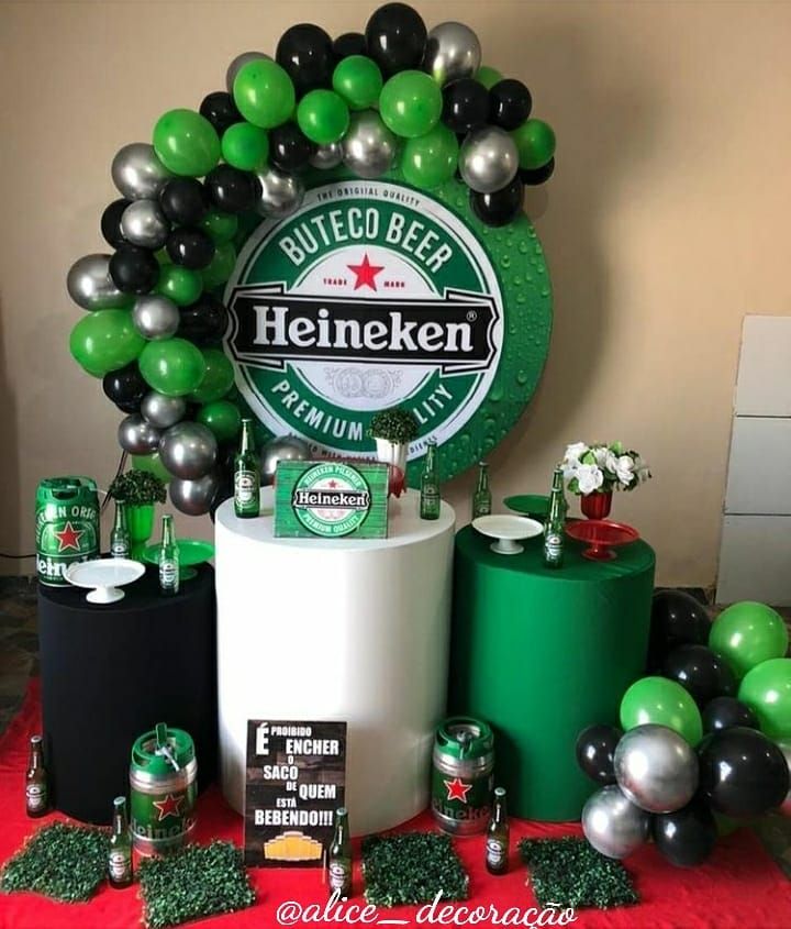 a table topped with balloons and beer bottles next to other items in front of a sign