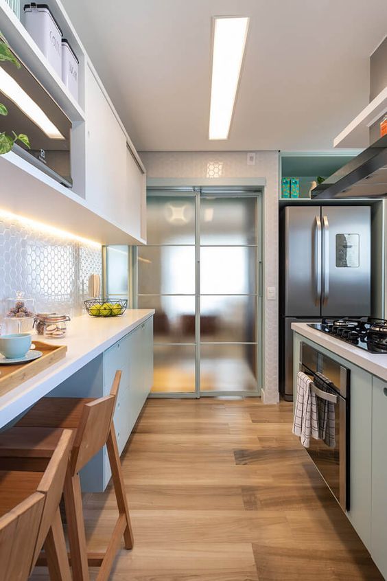 a modern kitchen with stainless steel appliances and wood flooring is pictured in this image