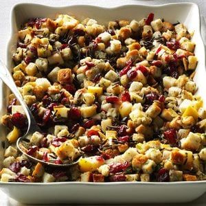 a casserole dish filled with stuffing and cranberries