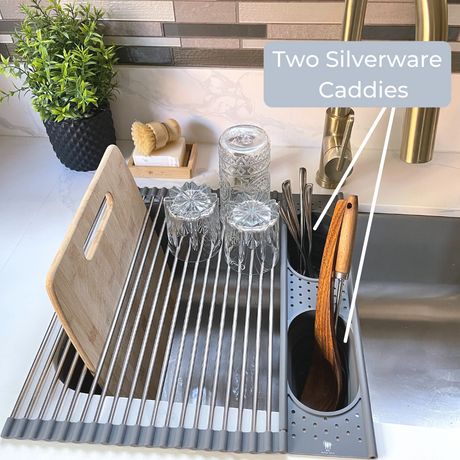 two silverware caddies sitting on top of a sink next to a cutting board