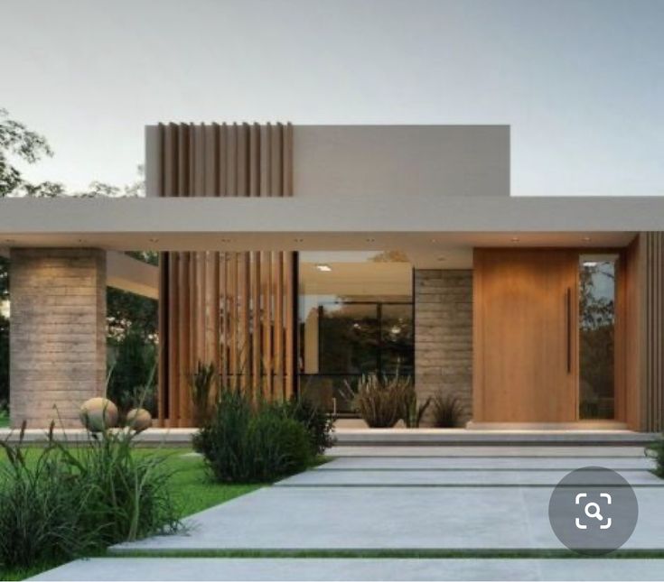 a modern house with grass and trees in the front yard