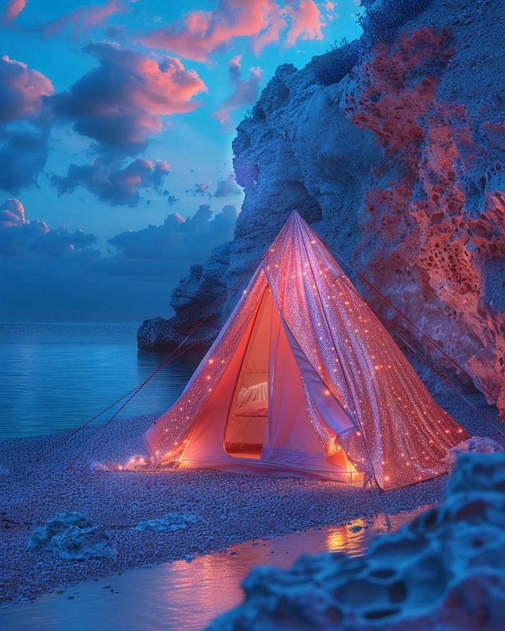 a tent is lit up on the beach at night