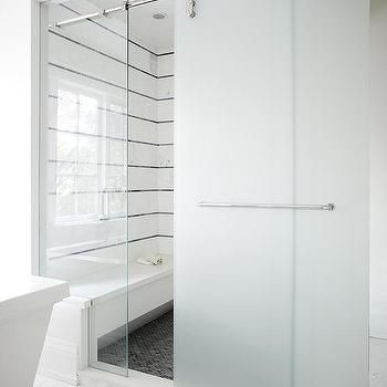 a white bathroom with a glass shower door