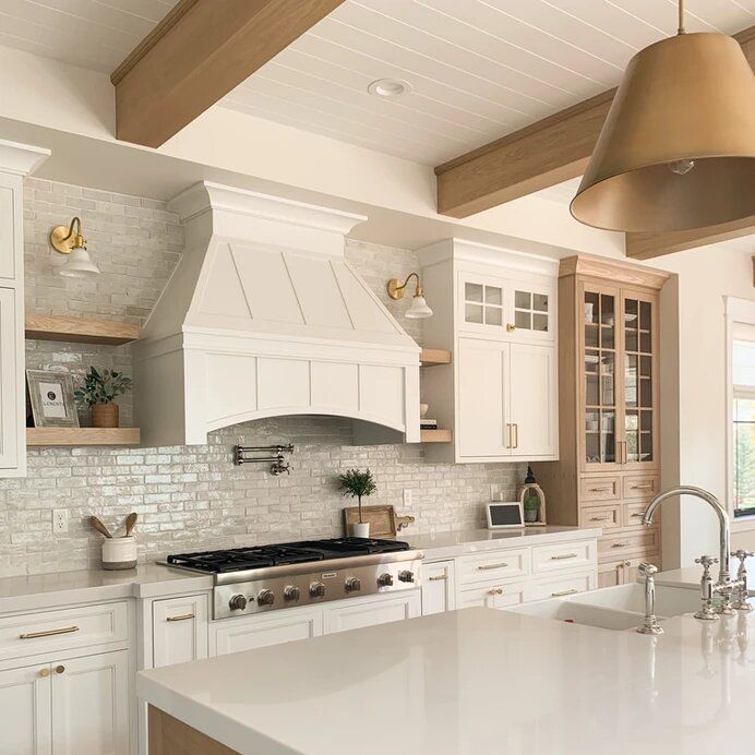 a large kitchen with white cabinets and an island in front of the stove top oven