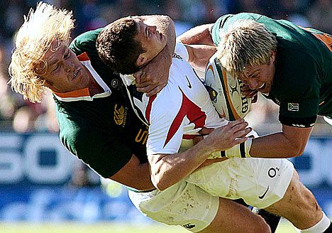 two rugby players colliding for the ball during a game