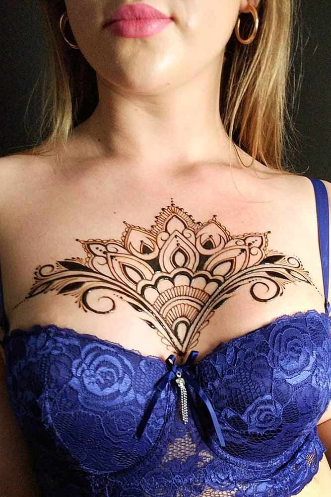 a woman with tattoos on her chest wearing a bra