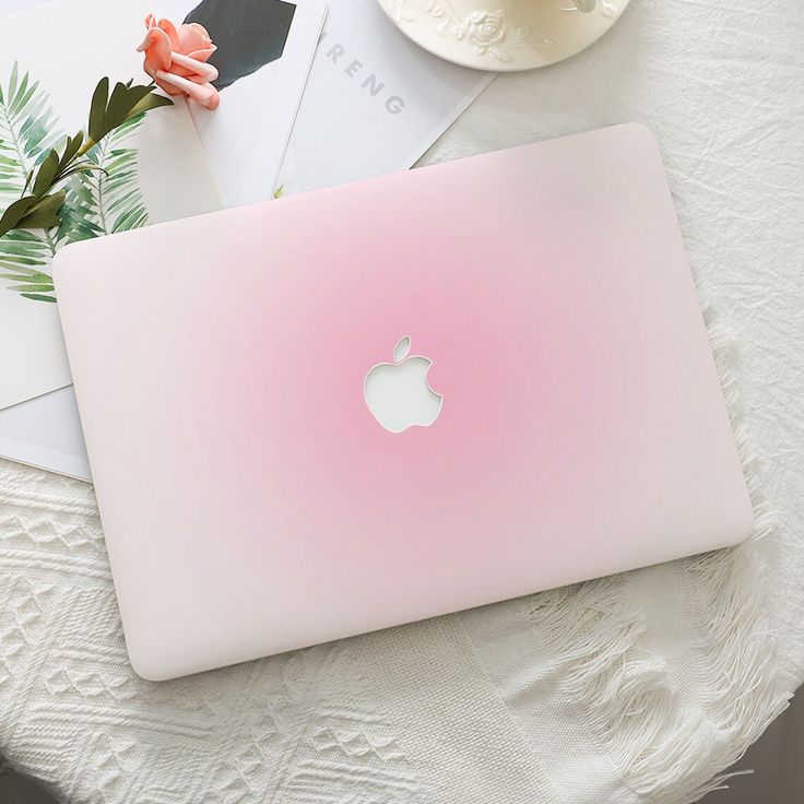 an apple laptop sitting on top of a white table next to flowers and cards with envelopes