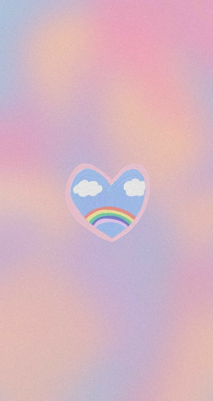 a heart shaped object floating in the air with clouds and rainbows on it's side