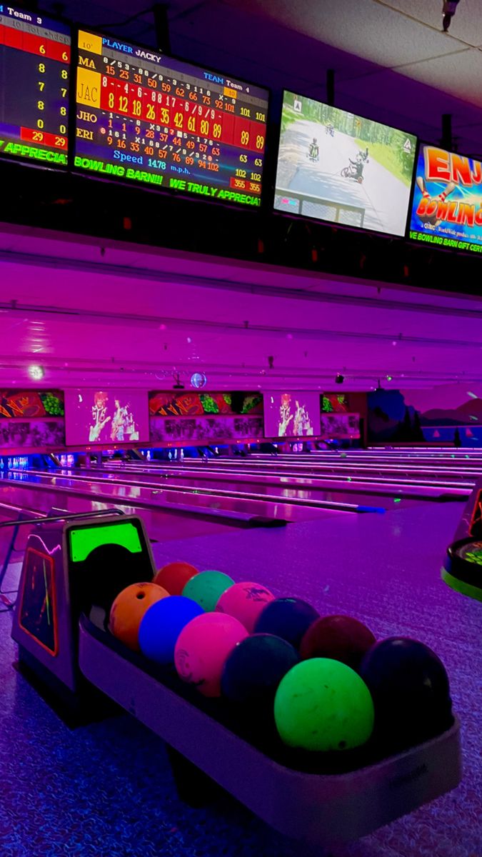 a bowling alley with neon lights and colorful balls in the bowl on the sidelines