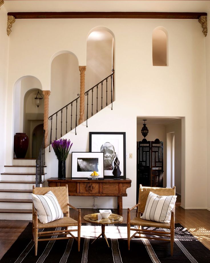 a living room filled with furniture next to a stair case