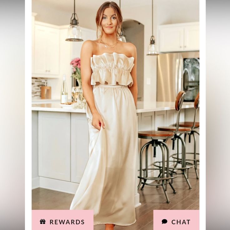 a woman standing in a kitchen wearing a white dress