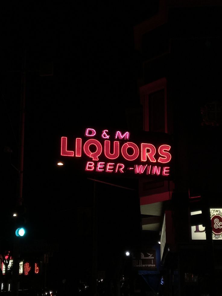 a neon sign that reads d & m liquors beer - wine