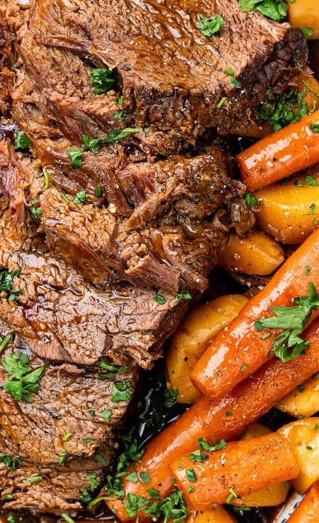 a plate with carrots, meat and potatoes on it next to some parsley