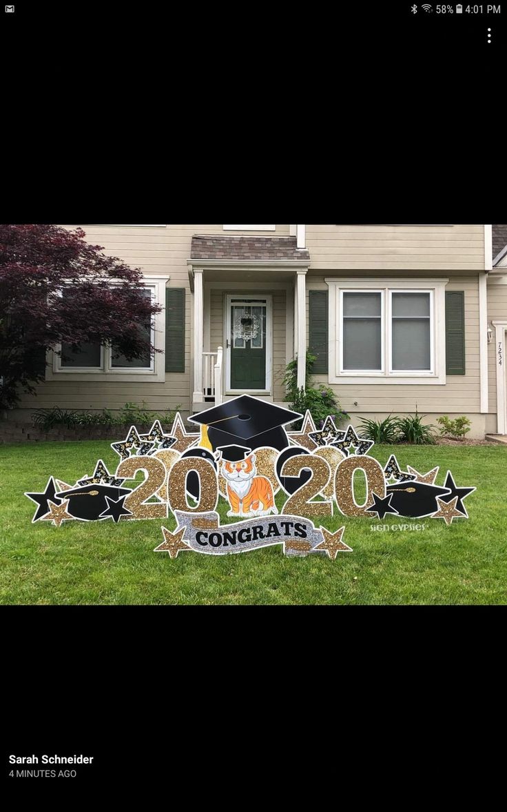 a graduation yard sign in front of a house that says congrats on it