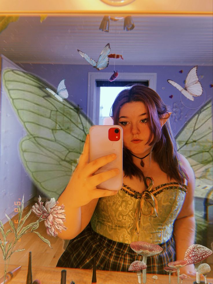 a woman is taking a selfie in front of a mirror with butterflies on it