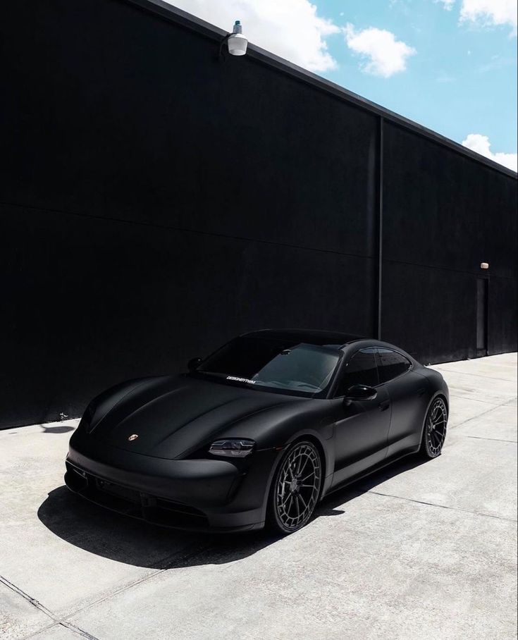 a black sports car parked in front of a building