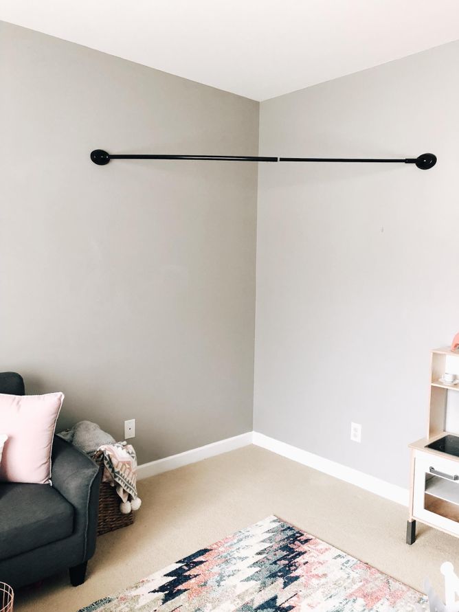 a living room with gray walls and a black chair in the corner next to a rug