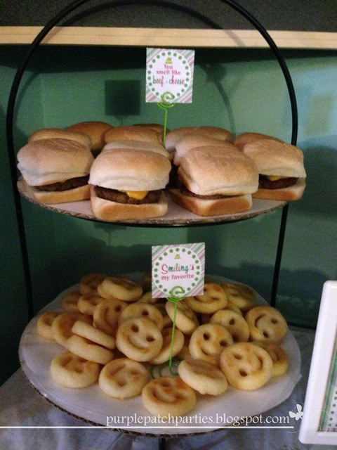 three tiered trays filled with sandwiches and pretzels