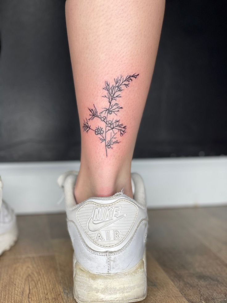 a woman's foot with a small flower tattoo on her left side calfocks