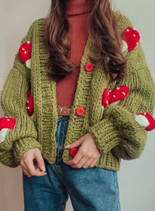 a woman wearing a green knitted cardigan with red and white hearts on it