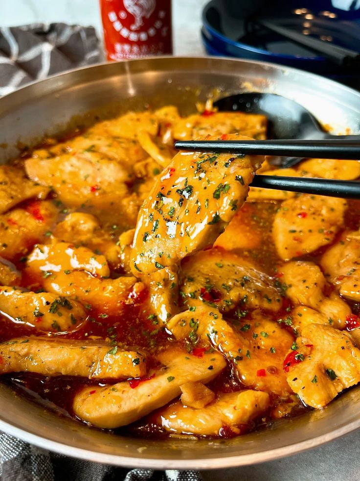 a pan filled with chicken and sauce on top of a table