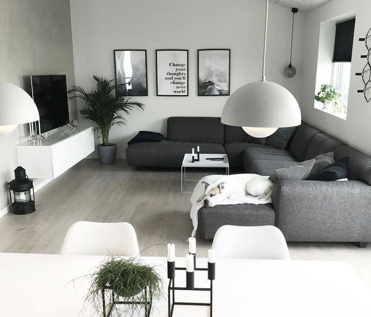 a living room filled with lots of furniture next to a white dining table and chairs